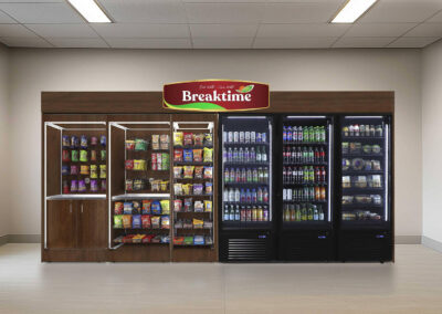 Premier micro market with dark woodgrain paneling, snack wall, and branded vending system