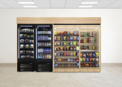 Premier micro market with light woodgrain finish, snack shelving, and beverage coolers