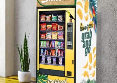 Vending machine with snack-themed wrap installed in corporate breakroom